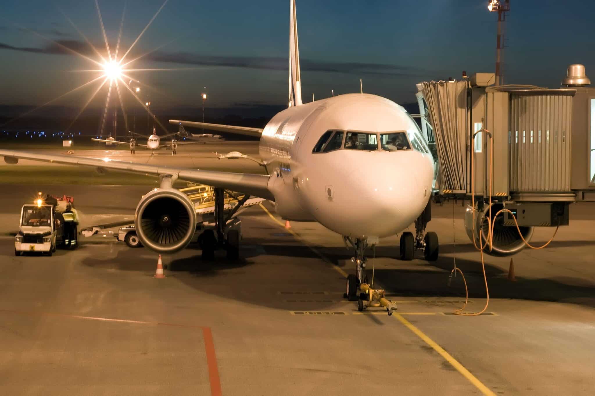 Commercial passenger aircraft at an airport gate at dusk, connected to a jet bridge, illustrating how AI vision is used in the aviation industry for ground operations monitoring, safety, and turnaround efficiency.