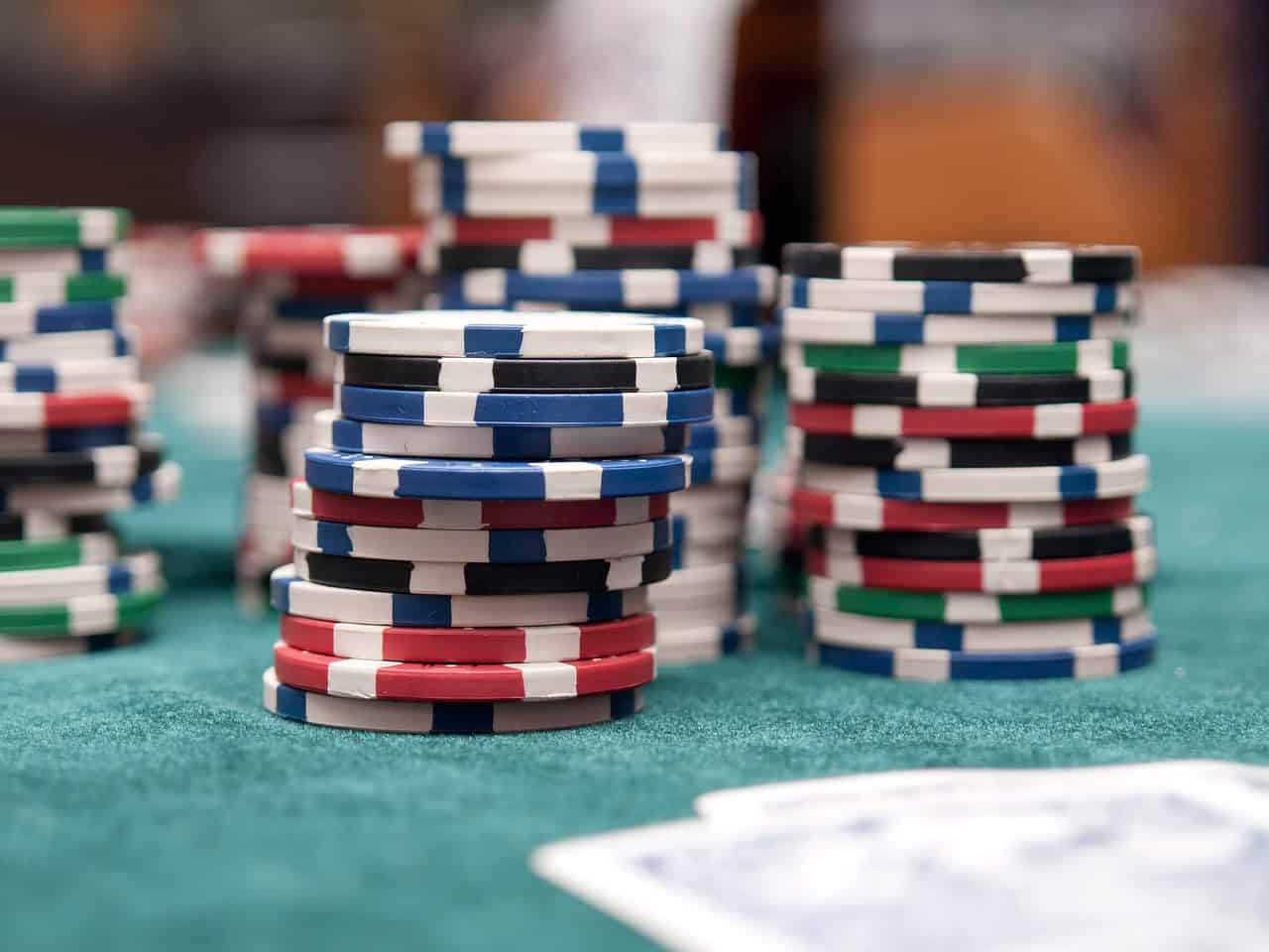 Stacks of multi-colored poker chips on a casino table, representing how AI vision is used in the hospitality, recreation, and entertainment sector for security, crowd control, fraud detection, and game integrity monitoring.